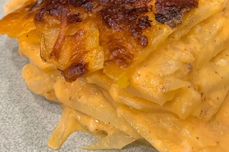 Scalloped potato recipe with cream, tomato sauce and cheese.